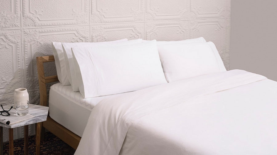 A bed made with Wright bedding